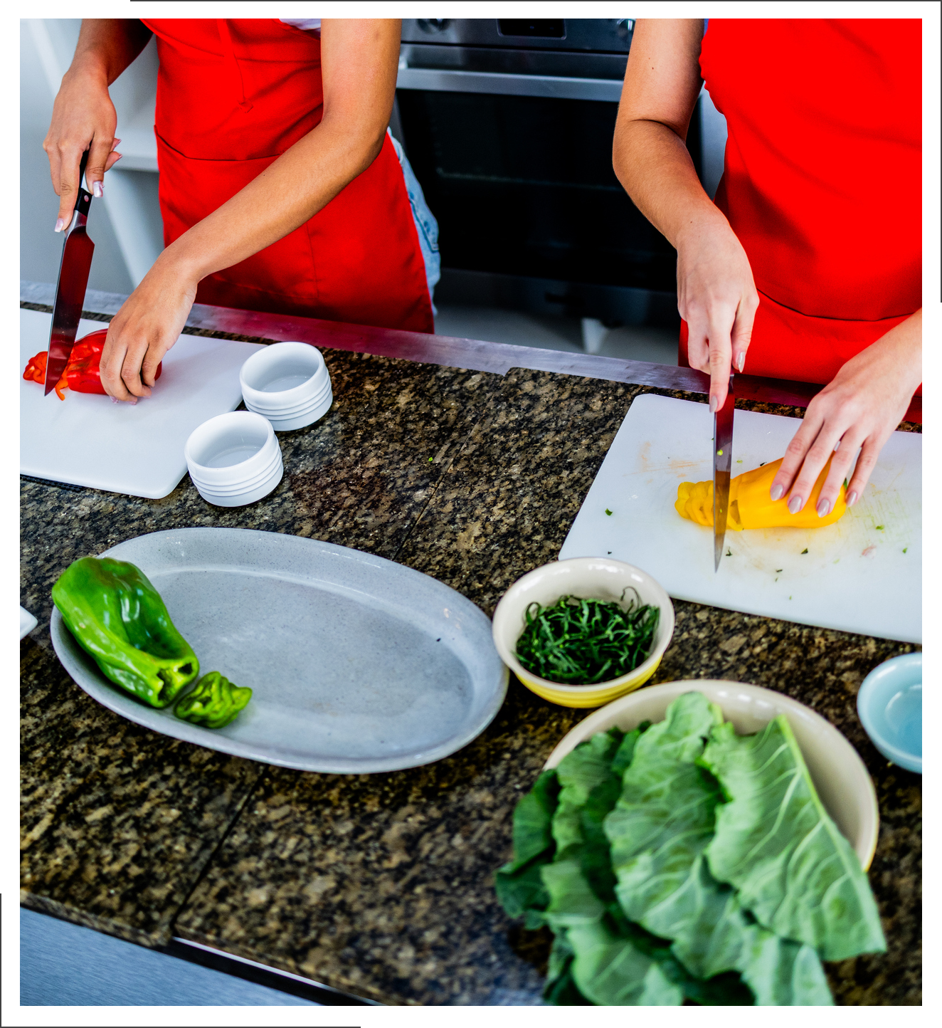 Two people chopping vegetables on a kitchen counter.